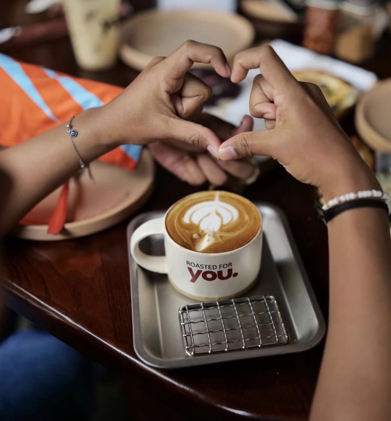 Earthly India custom work — hands sharing a co-branded cup